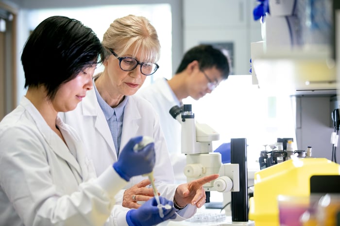 Three researchers work in a lab.