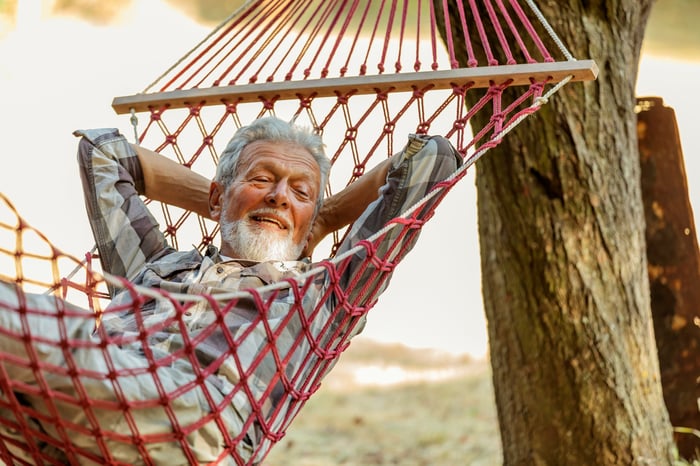 Smiling gray-haired person in hammock