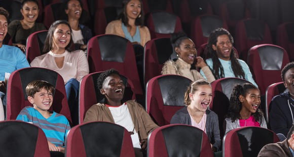Smiling people sitting in a movie theater.