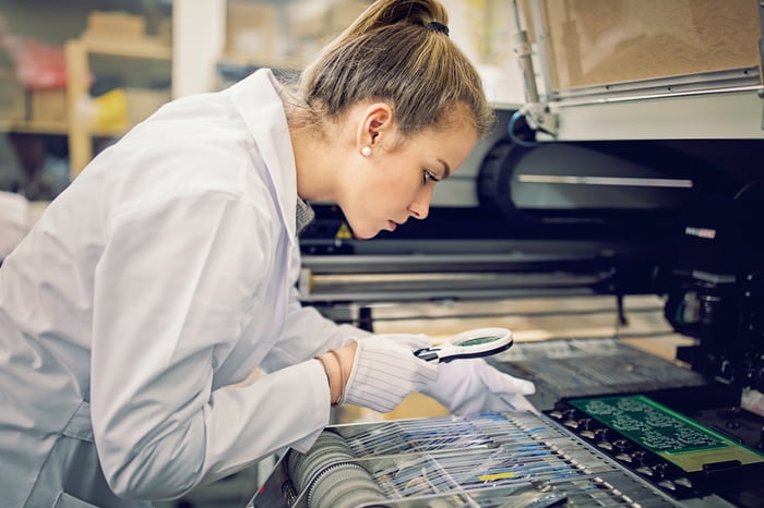 A person is working with resistors pick and place machine in circuit board factory