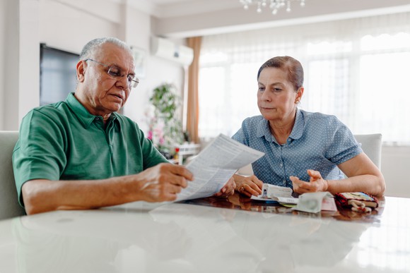 Two people at table looking at documents and receipts