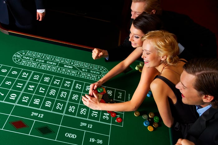 Four well-dressed players at a casino gaming table