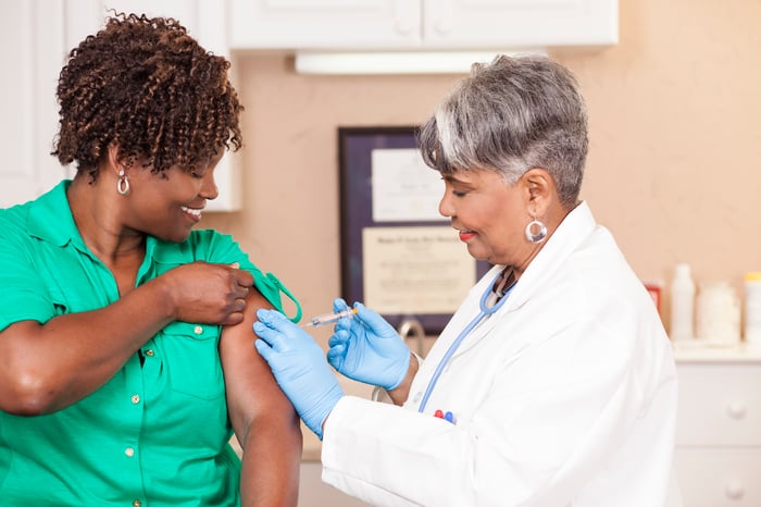 A physician administering a vaccine to a patient. 