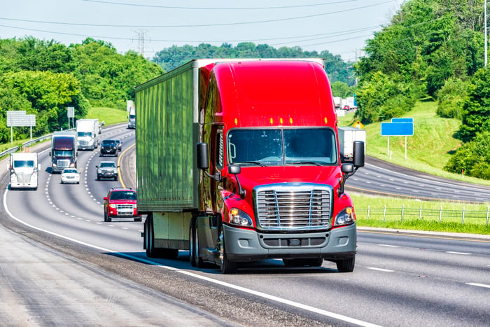 A semi-truck driving on a highway. 