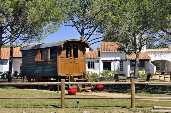 A tiny home in the shape of a wooden wagon.