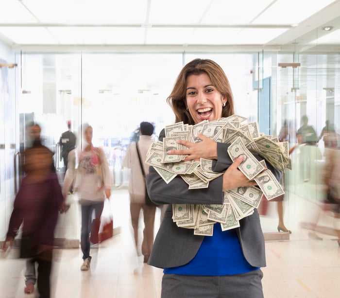 Happy person holding a lot of cash in public