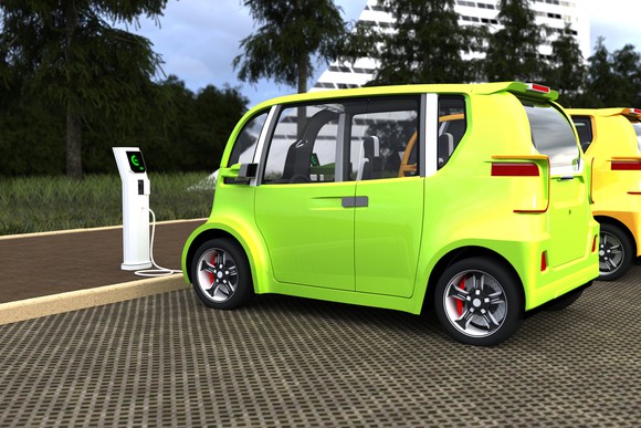 Green/yellow electric vehicle charging at a charging station.