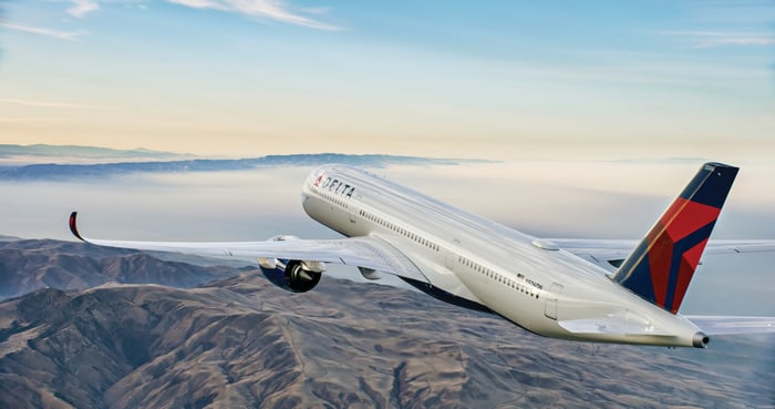 A Delta Air Lines Airbus A350 flying over mountains.