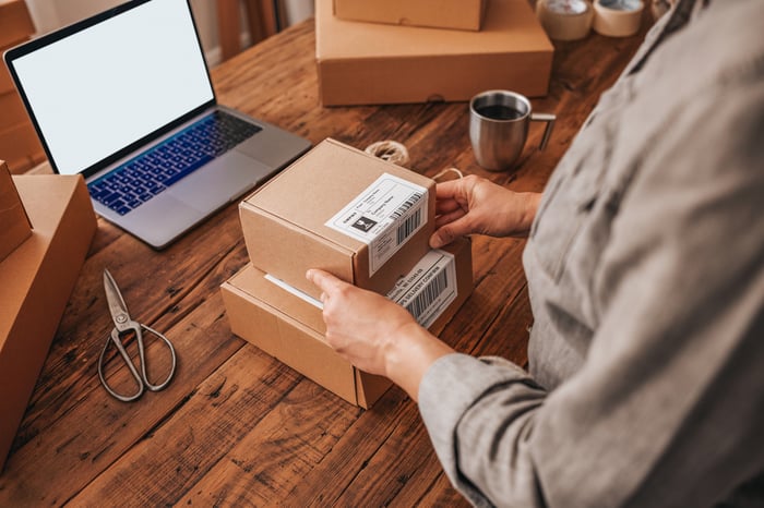 A person preparing packages to ship.