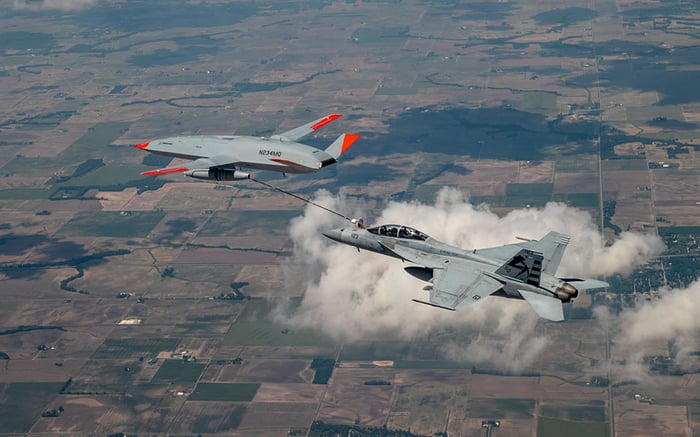 MQ-25 T1 prototype refueling F-18 fighter jet in flight.