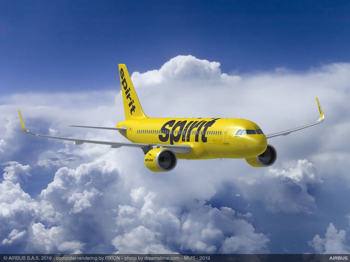 A rendering of a Spirit Airlines A320neo in flight, with clouds in the background.