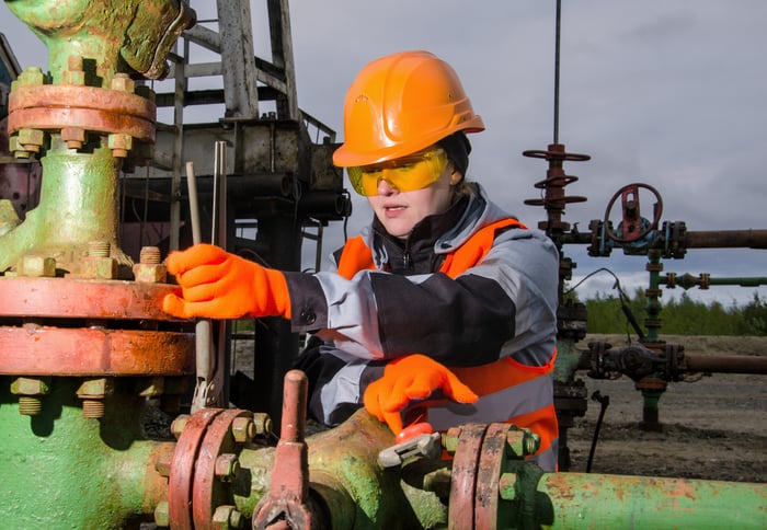 A person in protective gear working on an energy pipeline.