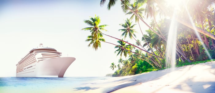 Cruise ship next to a beach with palm trees