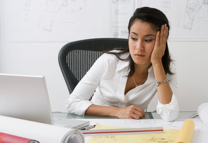 Person at desk looking at laptop suspiciously