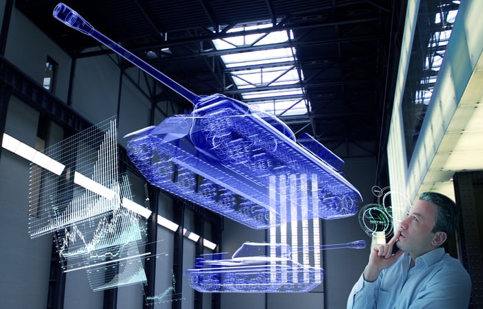 Engineer examining holographic designs of a futuristic tank