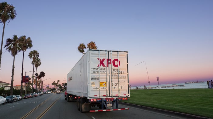 An XPO truck on a coastal road.