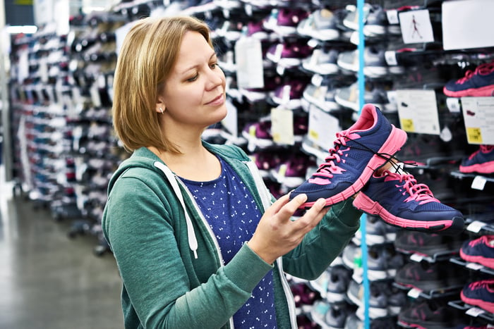 A person looking at shoes in a store.