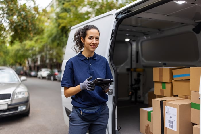 Courier checking packages for delivery.