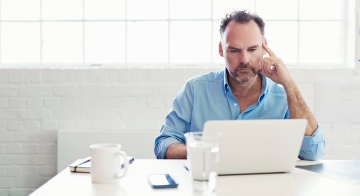 Person at laptop with serious expression