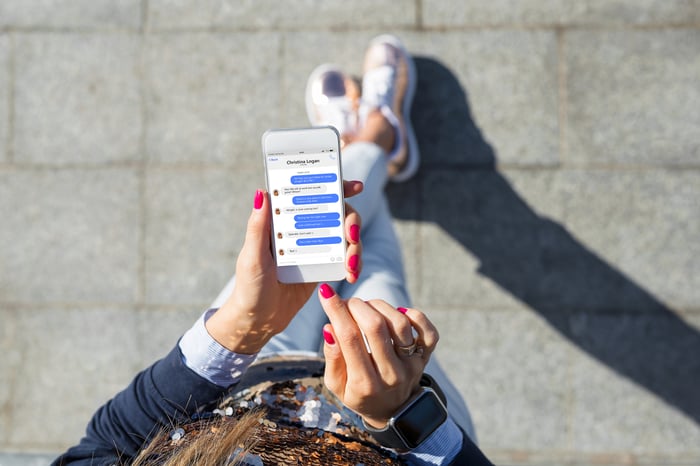 A person types messages on a phone.