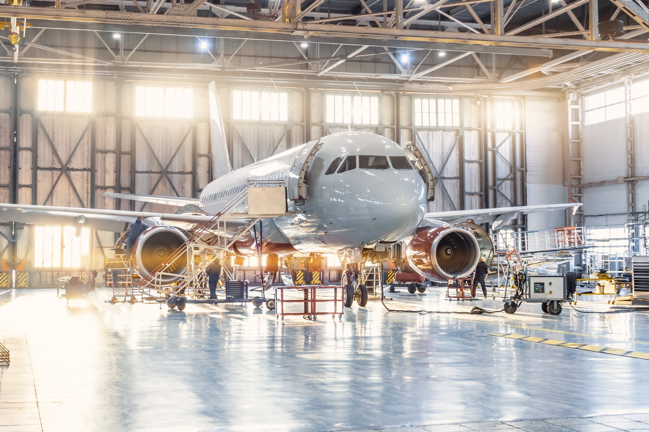View inside the aviation hangar, the airplane aerospace mechanic working around the service getty