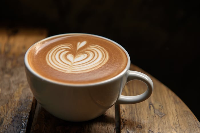 Latte sitting on wooden table.