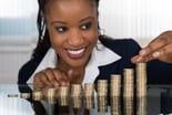 Investor with rising stacks of coins -- GettyImages-584001990