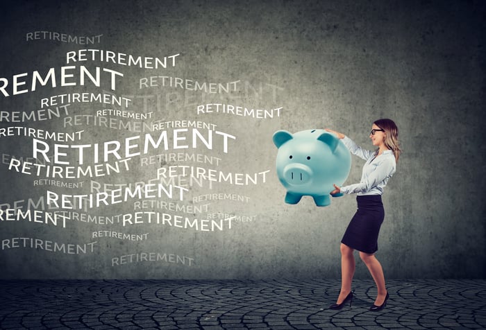 Person holding a piggy bank thinking about retirement.