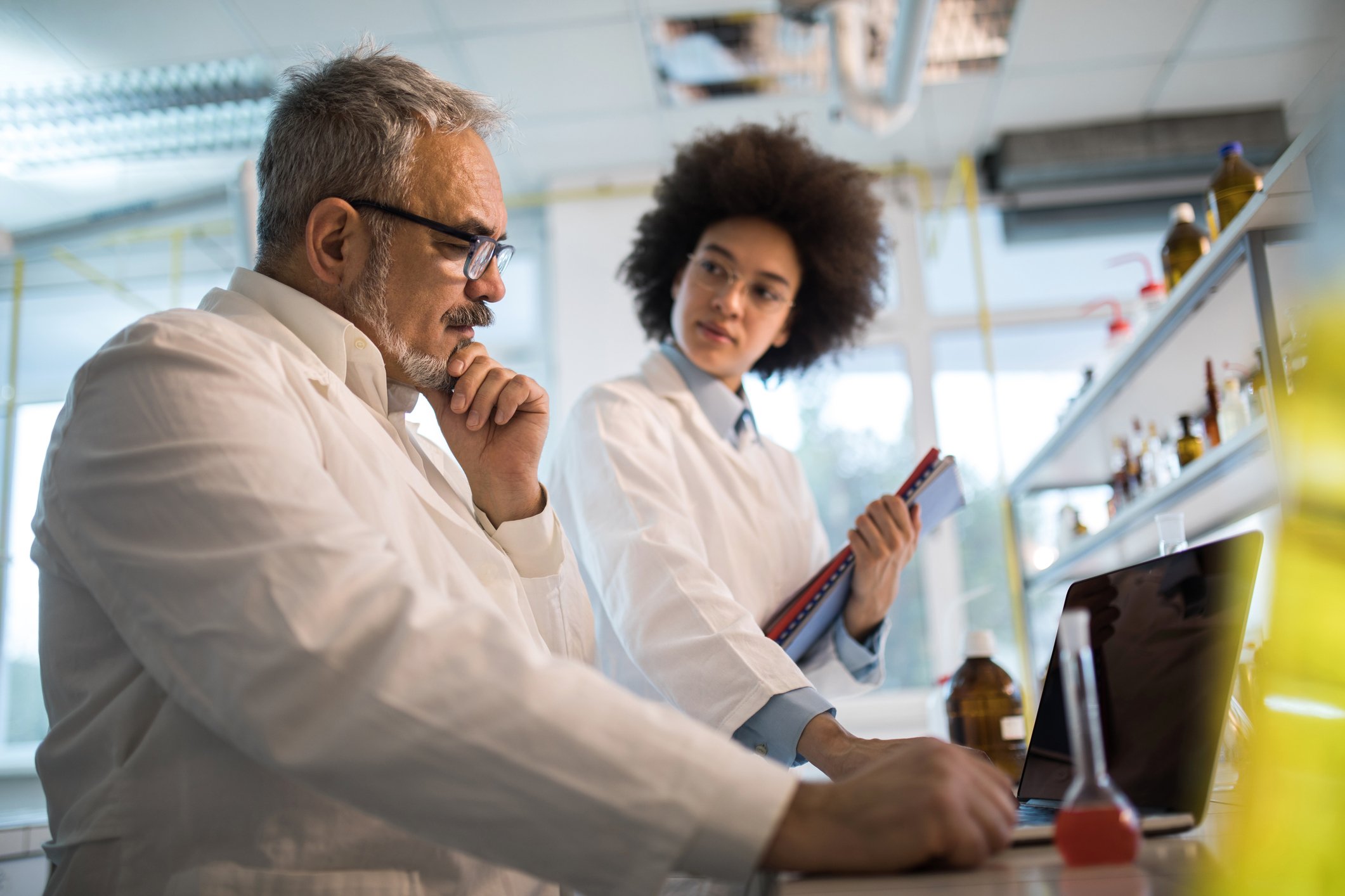 Lab technician colleagues considering ideas and options