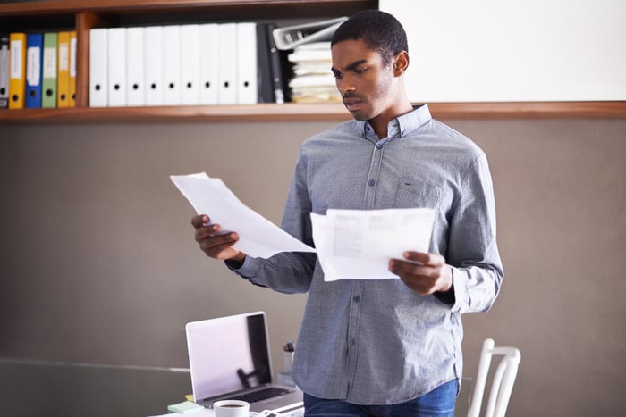 A person appears surprised by something they're reading on paper.