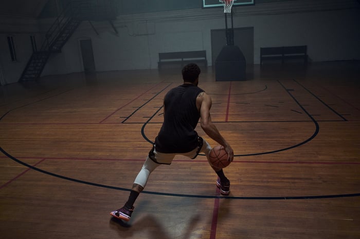 A basketball player with a ball on an indoor court.