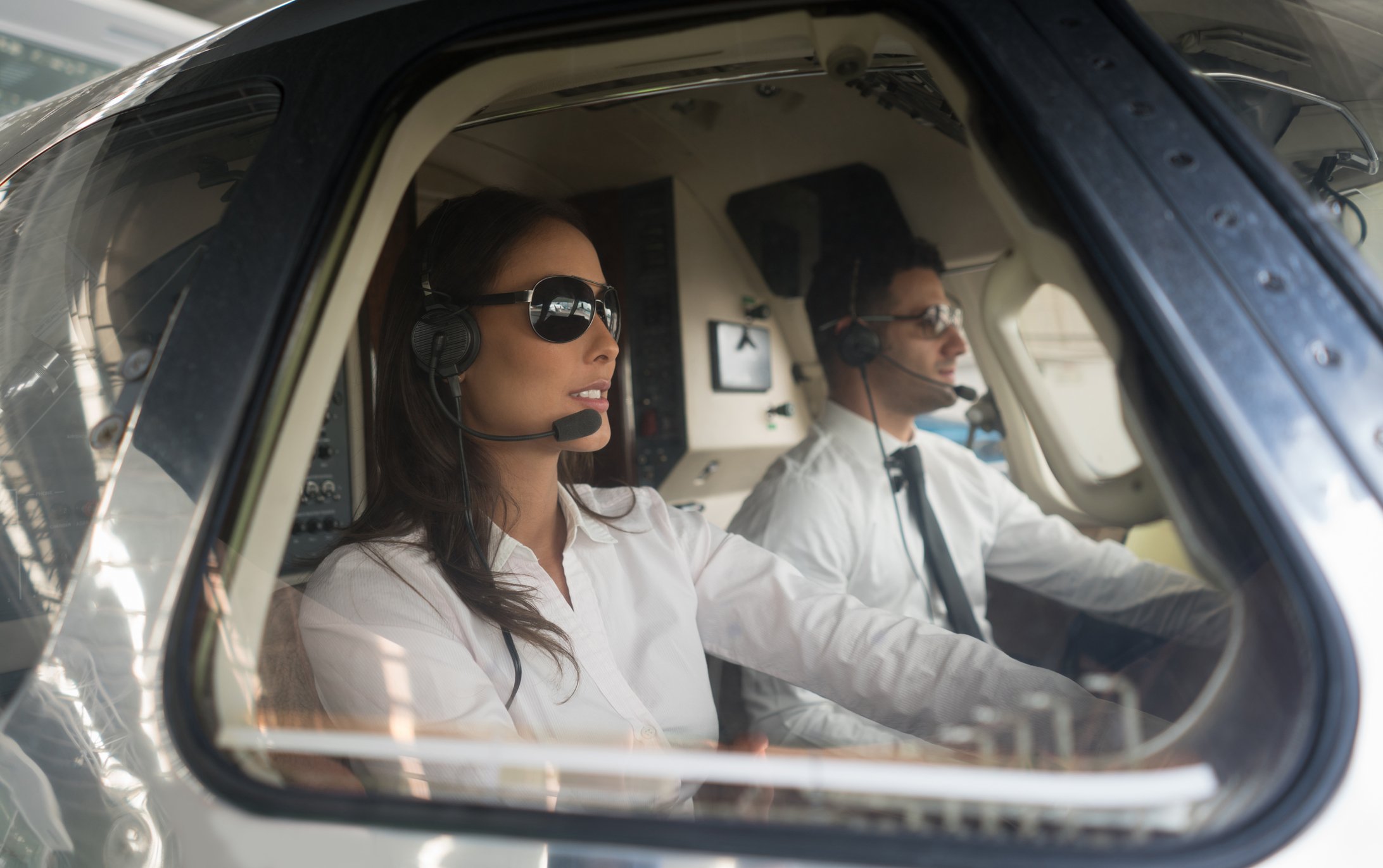Male pilot and woman copilot traveling by helicopter getty