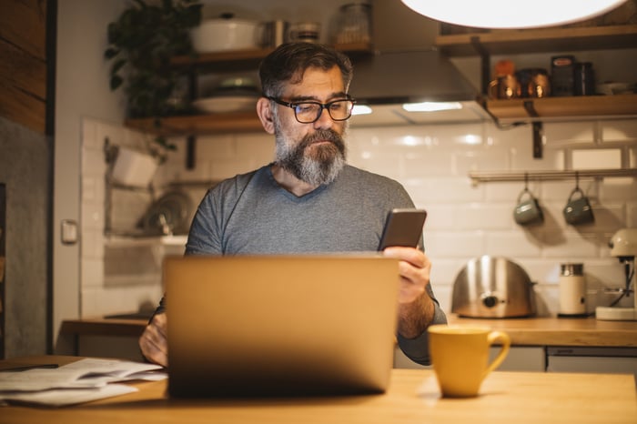 Person with a serious expression sitting in front of a laptop.