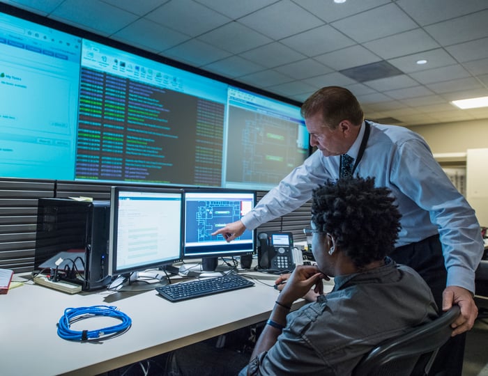 Two colleagues working together in server control room.