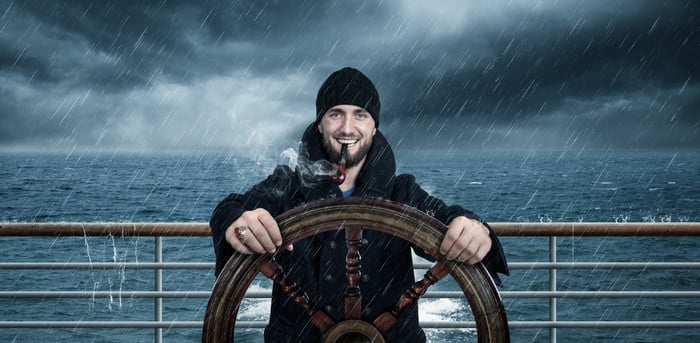 Captain sailing a boat during a storm.