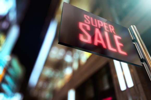 A lit LED sign in front of a store that reads, Super Sale.