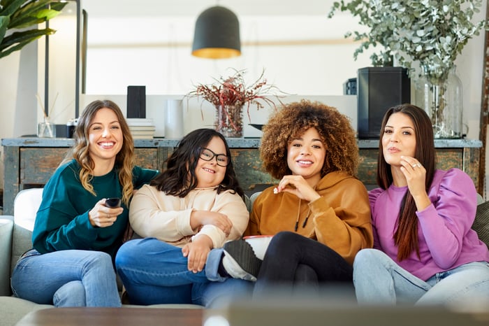 Four people sitting on a couch.