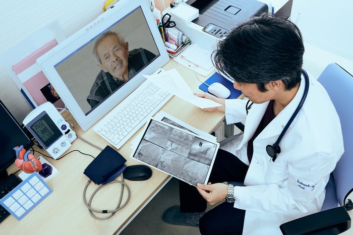 Doctor going over X-rays with patient on a telehealth call.