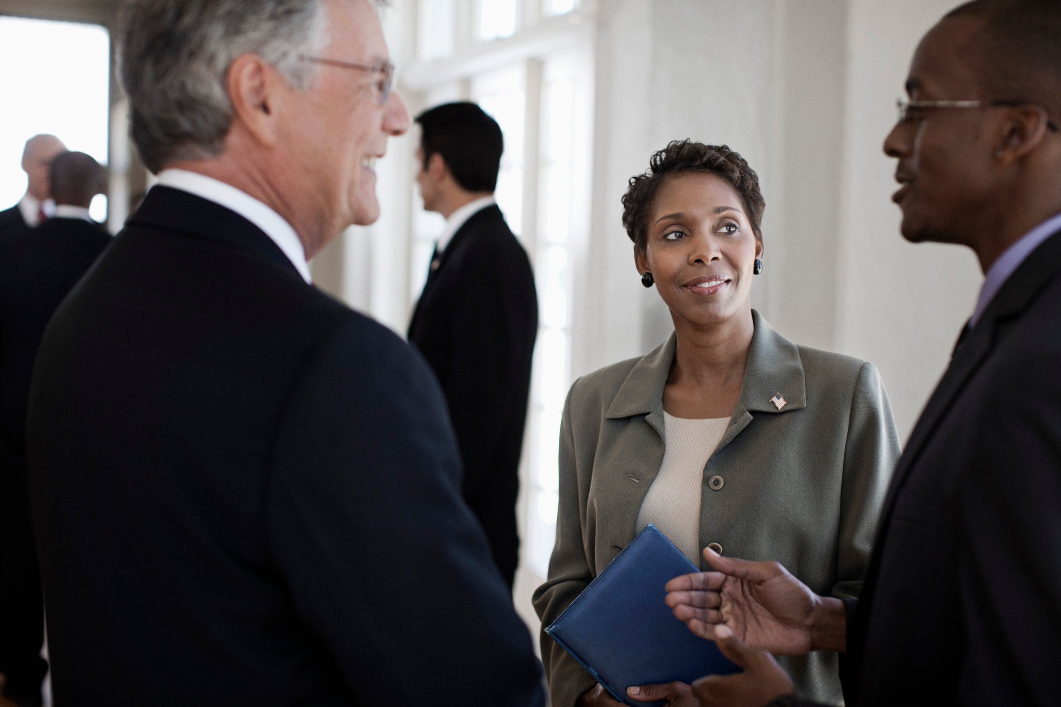 A group of business people talking inside a building.