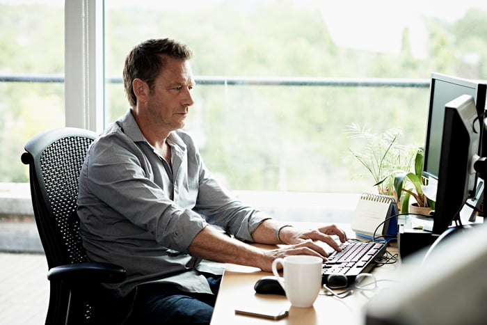 Person at computer typing on keyboard