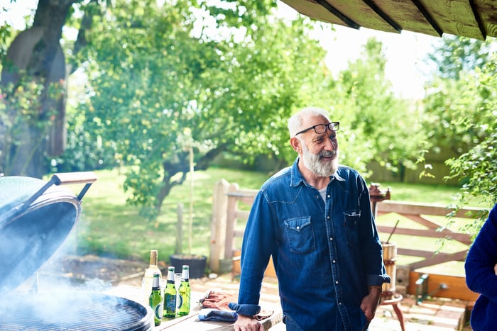 Smiling person standing near grill