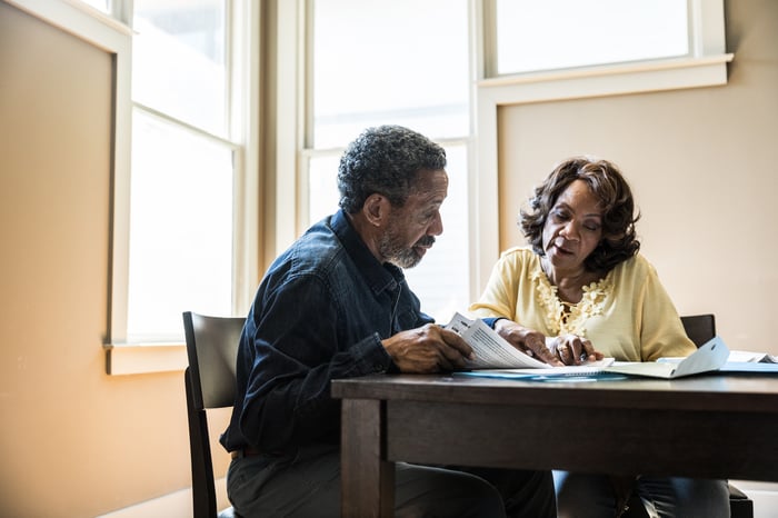 Two people sitting at a table looking at documents