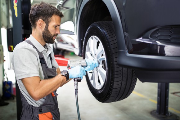 A service technician fitting a new tire.