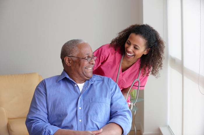 A nurse checking in on a patient at a senior housing facility. 