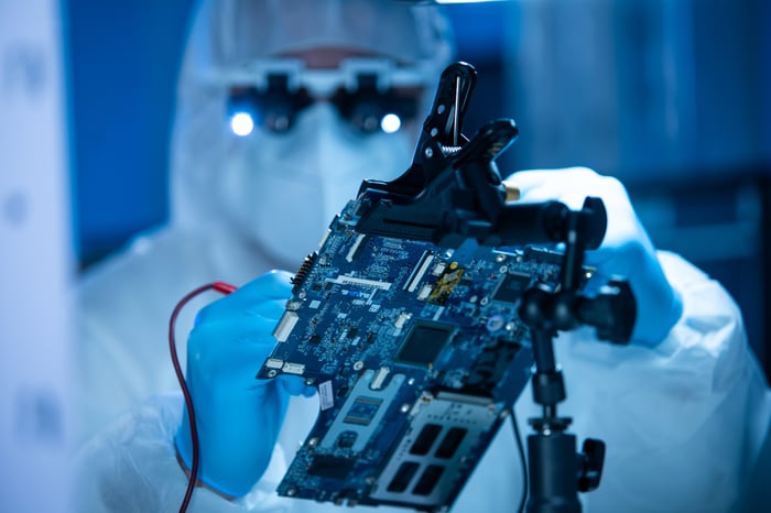 A computer chip manufacturing worker soldering a semiconductor.