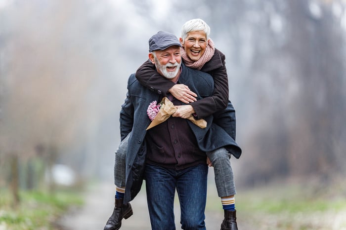 Two seniors walking happily together down the road.