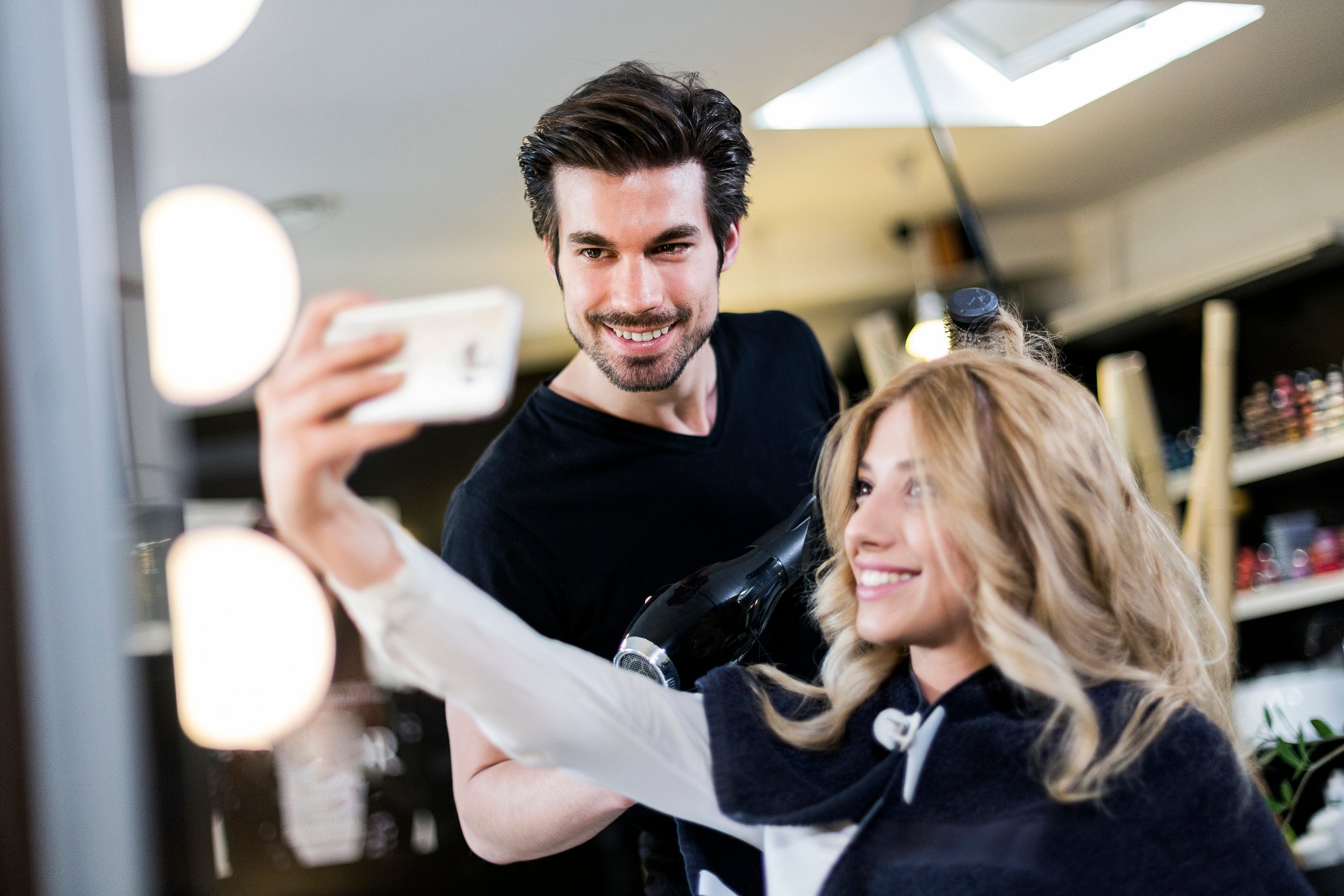 hair salon customer all smiles taking selfie with stylist