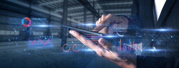 Investor places trade on tablet, while financial charts and data are displayed across the image.