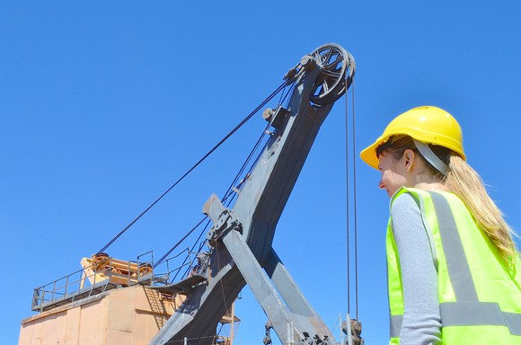 A mining engineer with heavy equipment in the background.