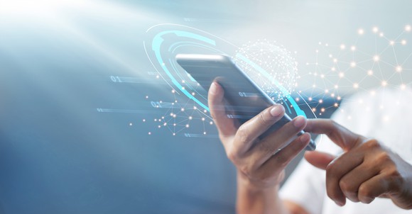 Closeup on hands operating a smartphone with animations around it.